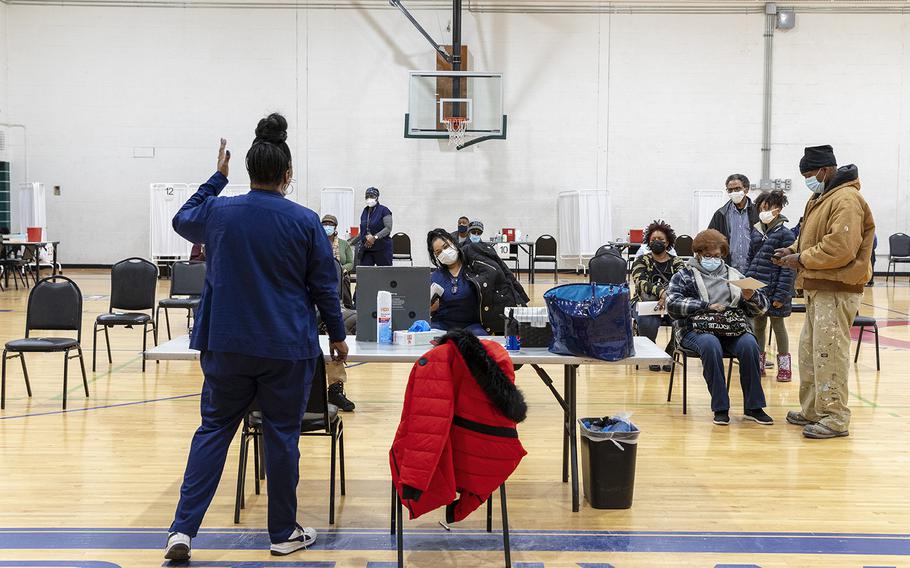 A medical professional speaks with people who just received a coronavirus vaccine in Detroit on Nov. 30, 2021. 