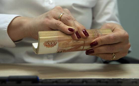 An employee handles 5000 ruble banknotes inside an Otkritie Bank FC PJSC branch in Moscow last year. MUST CREDIT: Bloomberg photo by Andrey Rudakov