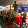 A college student does pull ups in front of military recruiters.