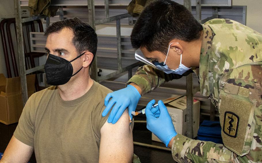 Pfc. Lake Goo gives a COVID-19 booster shot to U.S. Army Maj. William Lewis at Landstuhl Regional Medical Center in December 2021. Army health officials say the new booster shot that targets the omicron variant will arrive at Army bases in Europe in late September or early October.