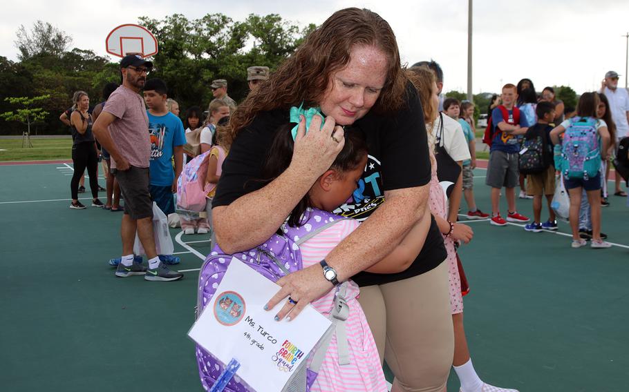Fourth-grade teacher Jill Turco consoles a crying student at Bob Hope Elementary School prior to the first day of classes at Kadena Air Base, Okinawa, Monday, Aug. 21, 2023.