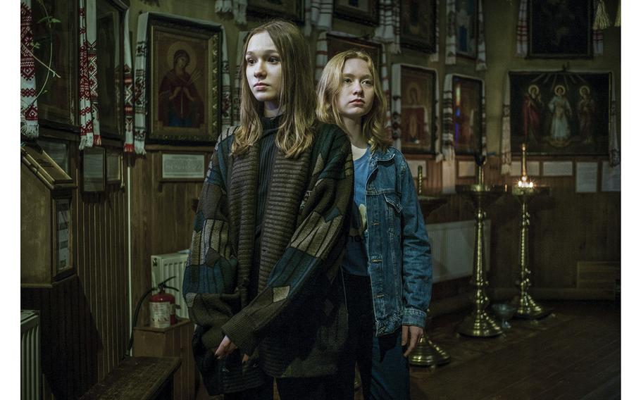 Daria Mileyko, left, and her sister Maria in the Ukrainian Orthodox church their family attends in the Obolon neighborhood of Kyiv. 