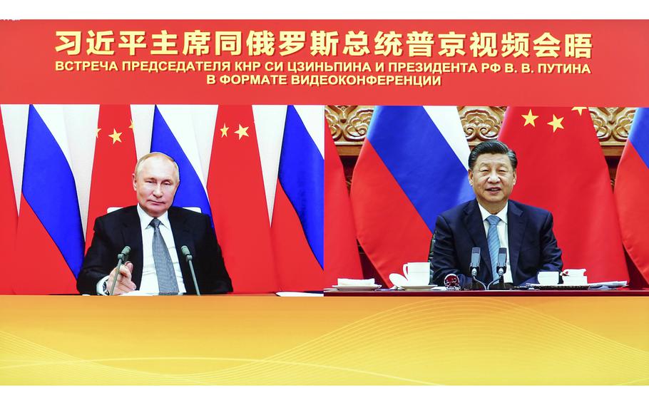 A composite photo shows Chinese President Xi Jinping, right, attending a virtual meeting in Beijing, on Wednesday, Dec. 15, 2021, with Russian President Vladimir Putin who attended the videoconference from Moscow.