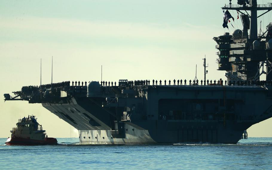 Sailors and marines line the deck of the aircraft carrier USS Abraham Lincoln (CVN-72) as it deploys from San Diego on Monday, Jan. 3, 2022. 