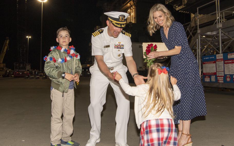 U.S. Navy Capt. Ryan Fulwider, executive officer of the aircraft carrier USS Nimitz, reunites with his family during the ship’s homecoming. 