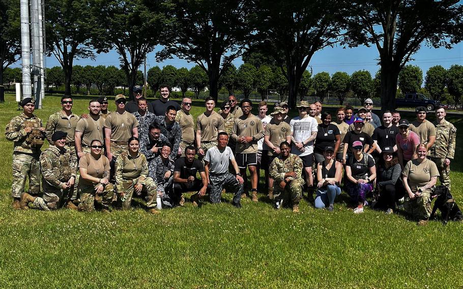 Airmen from the 374th Security Forces Squadron pose with volunteers and members form the Japanese Air Self Defense Force following memorial ruck march at Yokota Air Base, Japan, May 16, 2023.