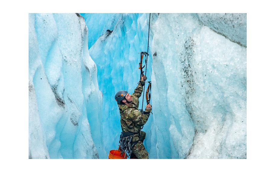 U.S. Army Sgt. Nathaniel Smith, 2nd Infantry Brigade Combat Team, 11th Airborne Division, Glacier Mountaineering Team advanced military mountaineer, scales a crevasse wall after recovering human remains, personal effects and equipment between glacier ridges at Colony Glacier, Alaska, June 16, 2023.
