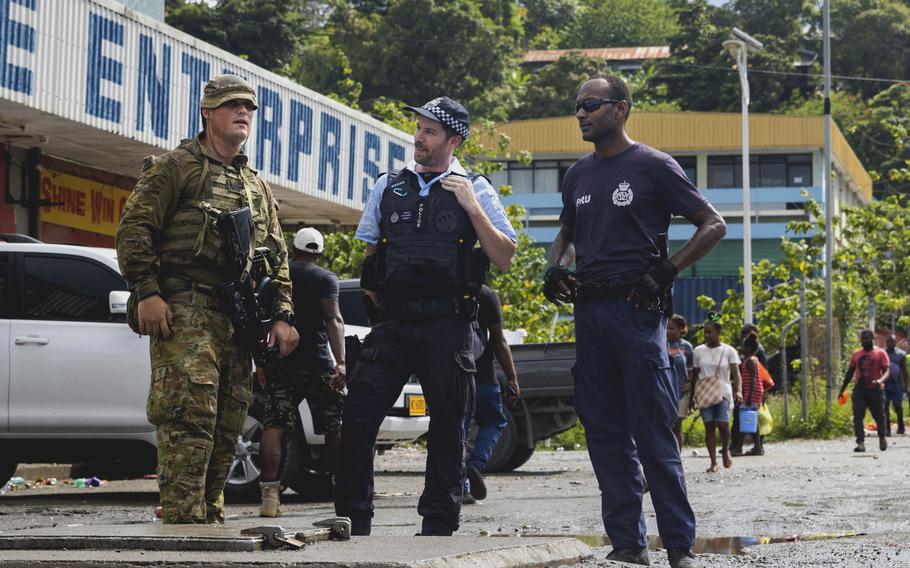 Australian Army Pvt. Nicholas Funch-Thomsen, Australian Federal Police Constable Dylan Gloury and an officer from the Royal Solomon Island Police Force talk during a patrol at the Port of Honiara, Solomon Islands, on Dec. 15, 2021. 