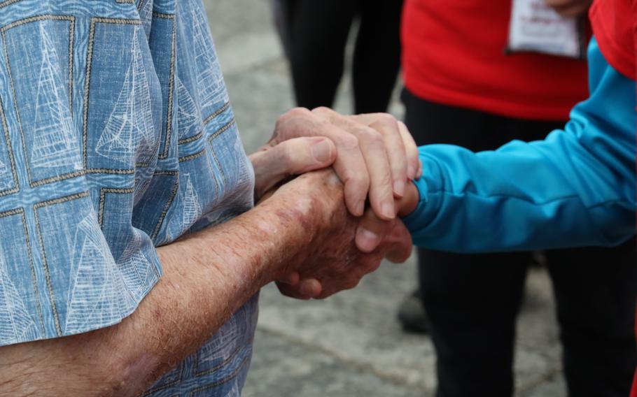 World War II veteran Les Jones, left, grasps the hand of a student from Kenosha, Wis., at the World War II Memorial on the National Mall in Washington, D.C., on Memorial Day, May 29, 2023.