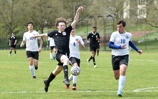 Baumholder winger Trevor Cheney lobs a shot as Brussels center back Antonio Pranjic tries to get back during a May 4, 2024, match at Minick Field in Baumholder, Germany.