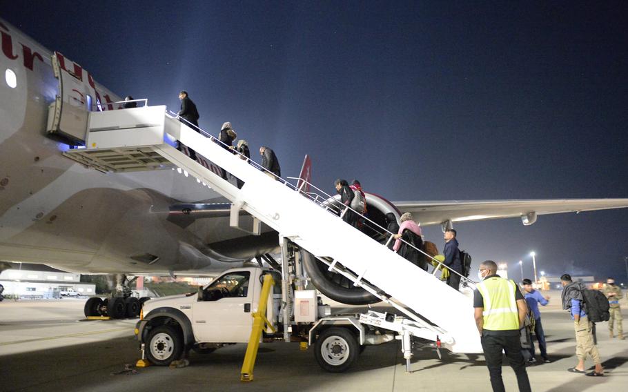 Afghans board an Omni Air International flight to the United States at Ramstein Air Base, Germany, Saturday, Oct. 9, 2021. The flight was the first to leave Ramstein for the U.S. since health officials halted flights three weeks ago, after measles cases were diagnosed in some evacuees.