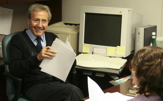 A man smiles at a woman in an office.