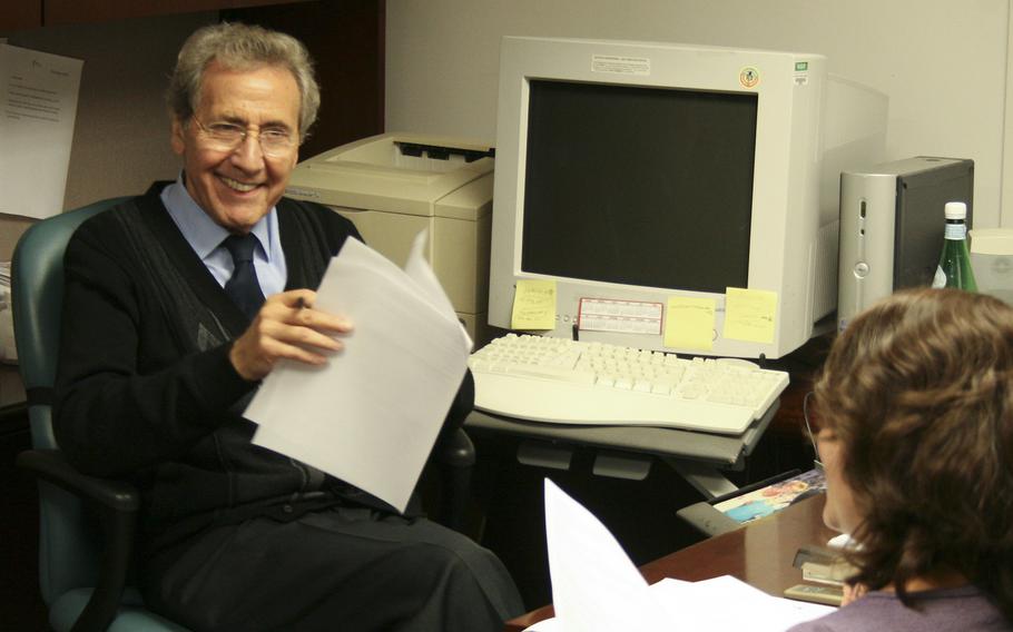 A man smiles at a woman in an office.