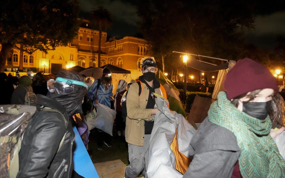 Pro-Palestinian demonstrators remove belongings from an encampment after police arrived on the campus at the University of Southern California, Sunday, May 5, 2024, in Los Angeles. 