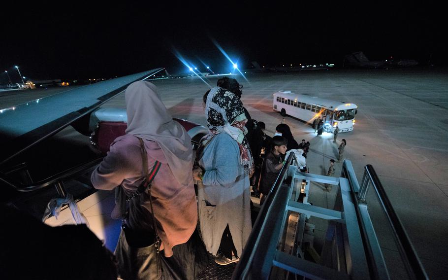 Evacuees board a flight to the U.S. from Ramstein Air Base, Germany, Saturday, Oct. 9, 2021. The flight was the first to leave Ramstein after a three-week pause, imposed by health officials after measles cases were detected in several Afghans after they had arrived in the U.S. from overseas bases. 