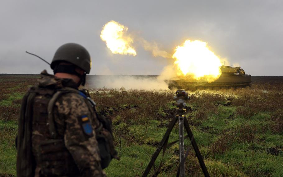 A Ukrainian soldier stands as a 2S1 Gvozdika self-propelled howitzer fires a shell on the front line in Donetsk region Oct. 10, 2022, as Russian forces earlier launched at least 75 missiles at Ukraine, with strikes targeting the capital Kyiv, and cities in the south and west.