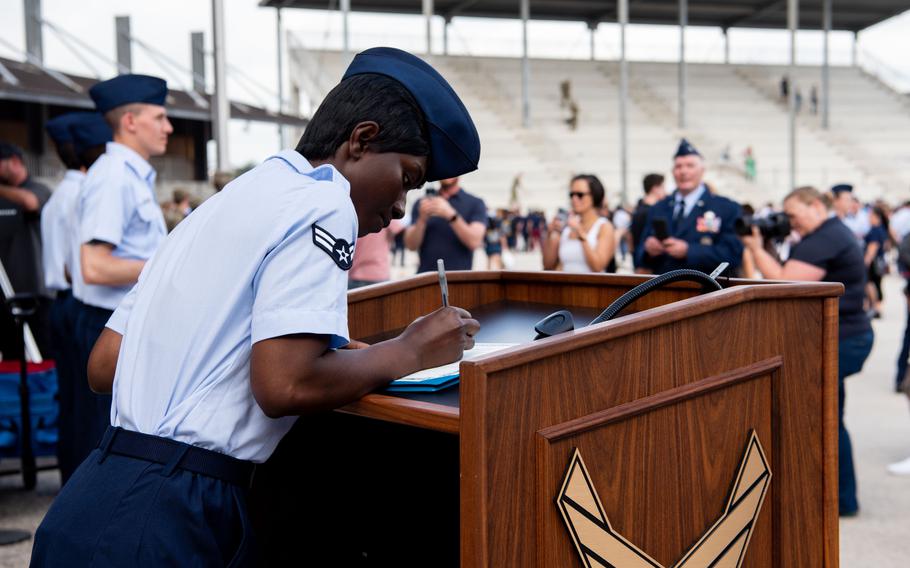 Airman 1st Class D’elbrah Assamoi of the Ivory Coast signs her U.S. Certificate of Citizenship on Wednesday, April 26, 2023, after the basic military training graduation ceremony at Joint Base San Antonio-Lackland, Texas. 