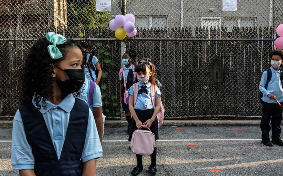 Students wait in line to enter a public school on the first day of classes in the Bronx borough of New York on Sept. 13, 2021. 