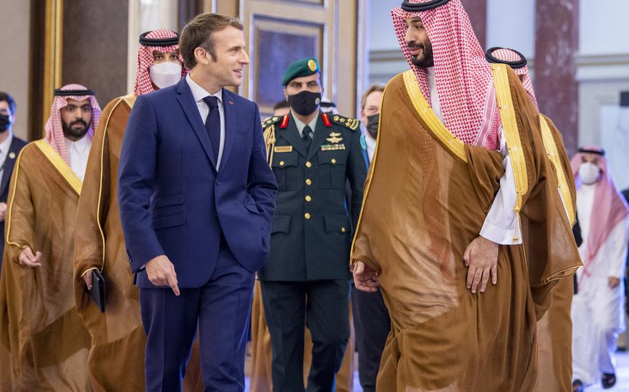 In this photo released by Saudi Royal Palace, Saudi Crown Prince Mohammed bin Salman greets French President Emmanuel Macron, left, upon his arrival in Jiddah, Saudi Arabia, Saturday, Dec. 4, 2021.