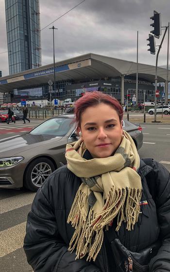 Justina Dziwicka, a child care worker, stands in front of the main train station in Warsaw that has become a hub for Ukrainian refugees. Born after Poland joined the North Atlantic Treaty Organization, she has never known life under Soviet domination. 