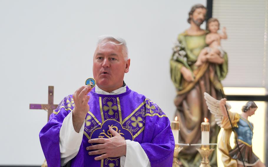 Father Daniel Mode, then chaplain of the U.S. Coast Guard, explains the meaning of his challenge coin at the Naval Base Guam chapel in Guam on Dec. 3, 2023. 
