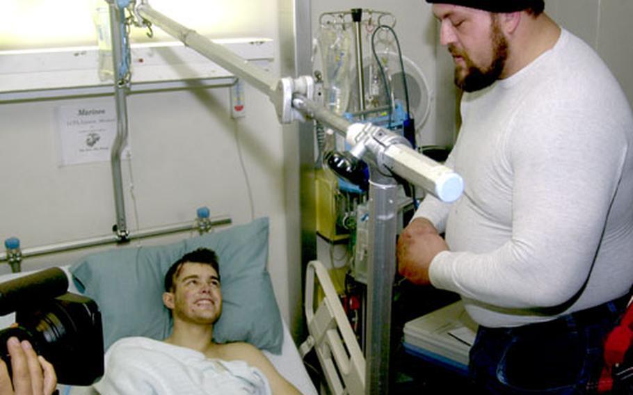 WWE wrestler Big Show talks with Marine Corps Lance Cpl. Michael Larson on Dec. 6, 2005, at Landstuhl Regional Medical Center in Germany. Larson had been injured by a buried explosive in Fallujah, Iraq.