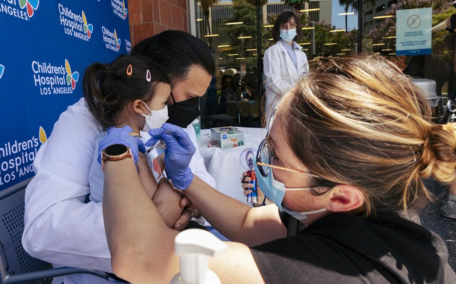 Sofia Espinoza Tam is held by her father, Children’s Hospital Los Angeles pediatrician Dr. Juan Espinoza, while nurse Monica Lopez administers the Pfizer COVID-19 vaccine Tuesday, June 21, 2022. 