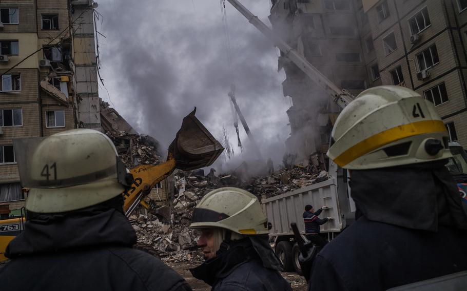 Rescuers continue to search for survivors in the ruins of a residential apartment complex that was hit by a Russian strike the day before in Dnipro, Ukraine, on January 15, 2023. 
