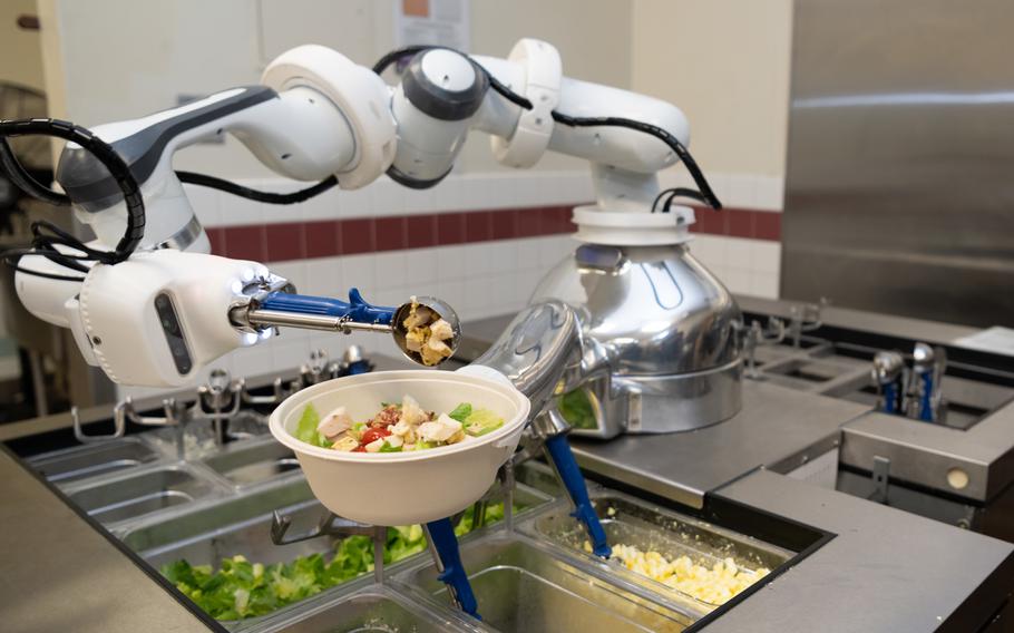 An food preparation robot, dubbed Alfred, prepares a salad Thursday, Dec. 9, 2021, at the Monarch Dining Facility on Travis Air Force Base, Calif., where officials are using and testing the system to see if it can increase productivity, reduce food waste and lower the risk of germ transmission.