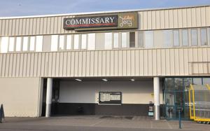 The entrance to a military grocery store is seen, with a sign above it reading “Commissary.”