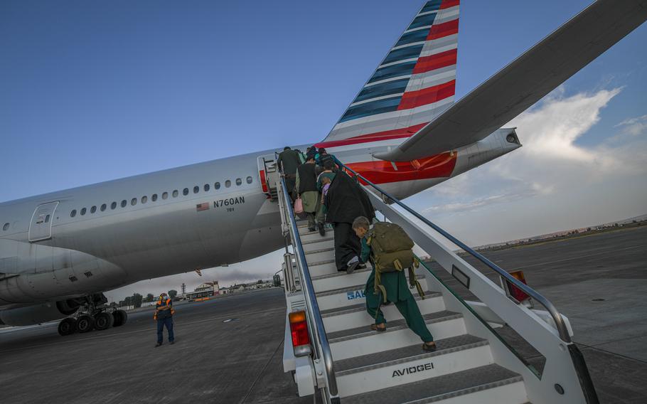 Evacuees from Afghanistan board a Boeing 777 bound for the United States from Naval Air Station Sigonella, Italy, Saturday, Aug. 28, 2021. Two evacuee flights left the air station over the weekend.