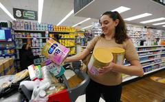 Michelle Saenz of Santee, Calif. buys baby formula at a grocery story across the border, Tuesday, May 24, 2022, in Tijuana, Mexico. As the baby formula shortage continues in the United States, some parents are opting to cross the border into Mexico, where the shelves are still stocked with options to feed their babies. (AP Photo/Gregory Bull)