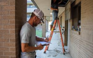 Jeremiah Partyke, maintenance mechanic for the Directorate of Public Works, writes up the work conducted as Nicole Stegall, maintenance worker helper with DPW, completes the work. (U.S. Army photo by Samantha Harms, Fort Cavazos Public Affairs)