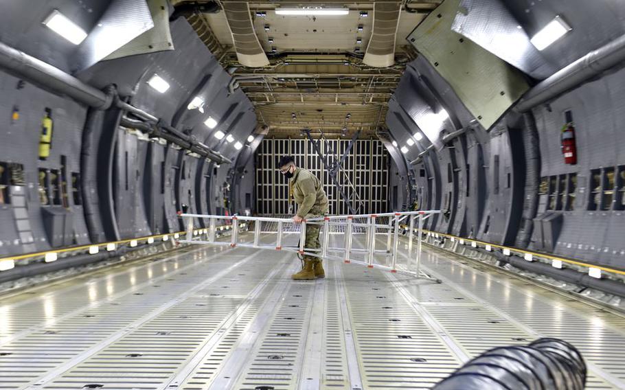 United States Air Reserve senior Airman Alex Lowe moves a ladder in the belly of a C-5M Super Galaxy in a maintenance hangar at Westover Air Reserve Base in Chicopee, Mass.   
