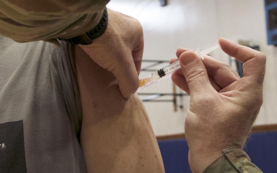 An Air Force medical technician injects the Moderna COVID-19 vaccine into a Japanese worker at Kadena Air Base, Okinawa.