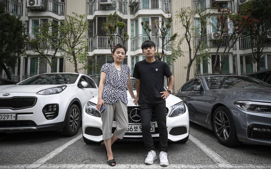 Im Su-ryuh and her son, Kim Kang-woo, pose in front of Kim's Mercedes-Benz in Seoul on July 12. 