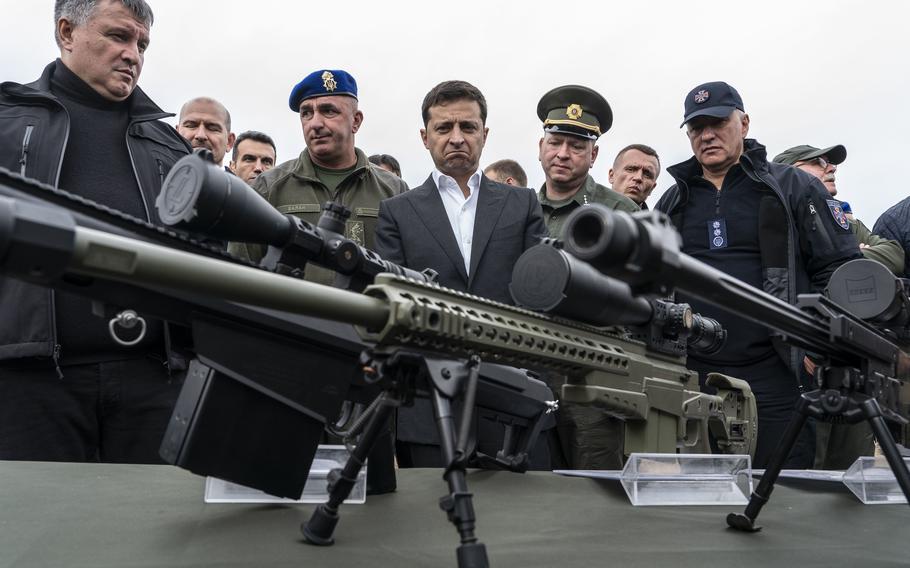 Volodymyr Zelenskyy inspects sniper rifles during a drill in Stare, Ukraine, in 2019. 