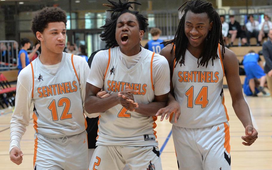 Spangdahlem’s Jeremy White, Makario Drummond and Messiah Smith, from left, celebrate their Division III title after defeating Hohenfels 65-63 in the division final at the DODEA-Europe basketball championships in Wiesbaden, Germany, Feb. 17, 2024. 