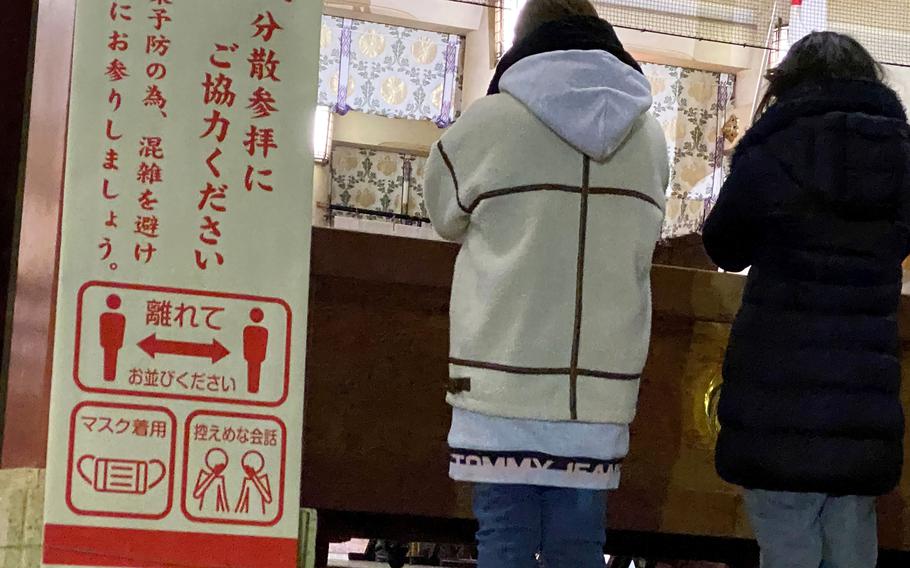 Worshippers are reminded to wear masks and practice social distancing at Setagaya Hachimangu Shrine in Tokyo, Jan. 1, 2022. 