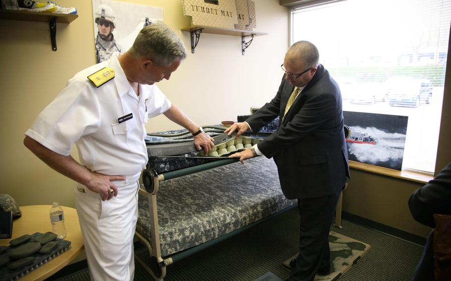 Rear Adm. James Shannon, former commander of the Naval Surface Warfare Center, inspects the cushioning for shipboard mattresses during the Denver Navy Week in 2011.