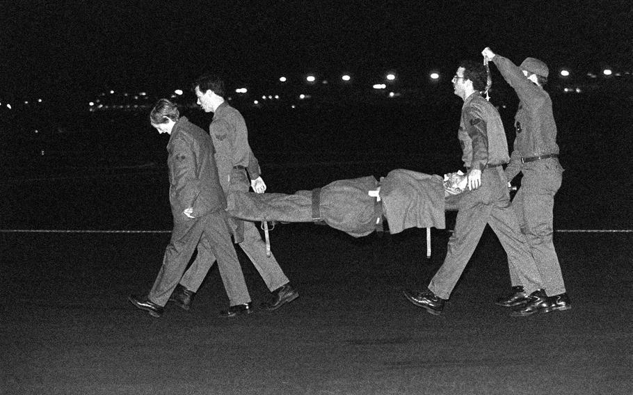 Members of the 2nd Aeromedical Evacuation Squadron carry a wounded Marine on a litter toward a bus for transport to Wiesbaden Air Force Regional Medical Center. The Marine was injured during a terrorist bomb attack on the barracks and headquarters building in Beirut, Lebanon.