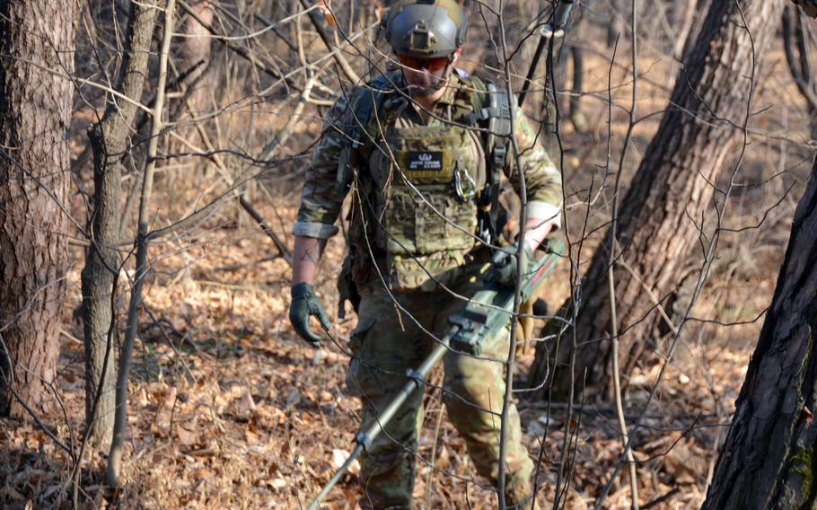 Army Staff Sgt. Austin Beekman uses a metal detector to find mock improvised explosive devices during the Korea EOD Team of the Year competition at Camp Humphreys, South Korea, Jan. 11, 2023. He's a member of the 718th Ordnance Company (EOD), 23rd Chemical, Biological, Radiological and Nuclear Battalion.