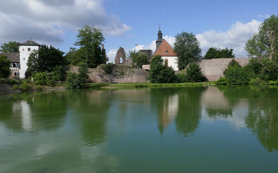 The white Untertor, an old city gate at left, and Burg Hayn, the town’s medieval castle, are reflected in a pond in Dreieichenhain, Germany.