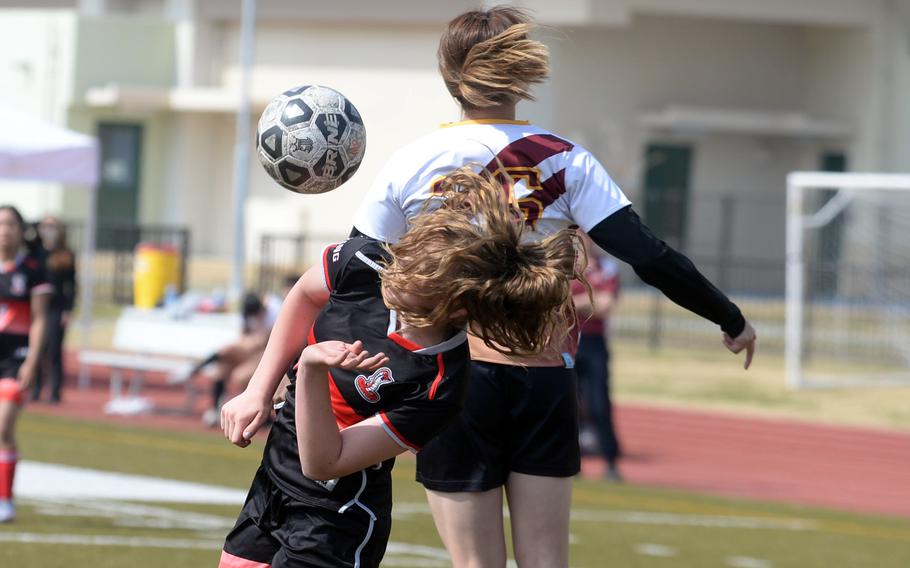 E.J. King’s Madylyn O’Neill and Marist Brothers’ Sakurako Yamamoto go up to head the ball.