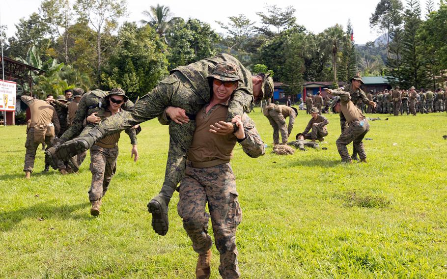 A man carries another person over his shoulders using a technique known as the fireman’s carry.