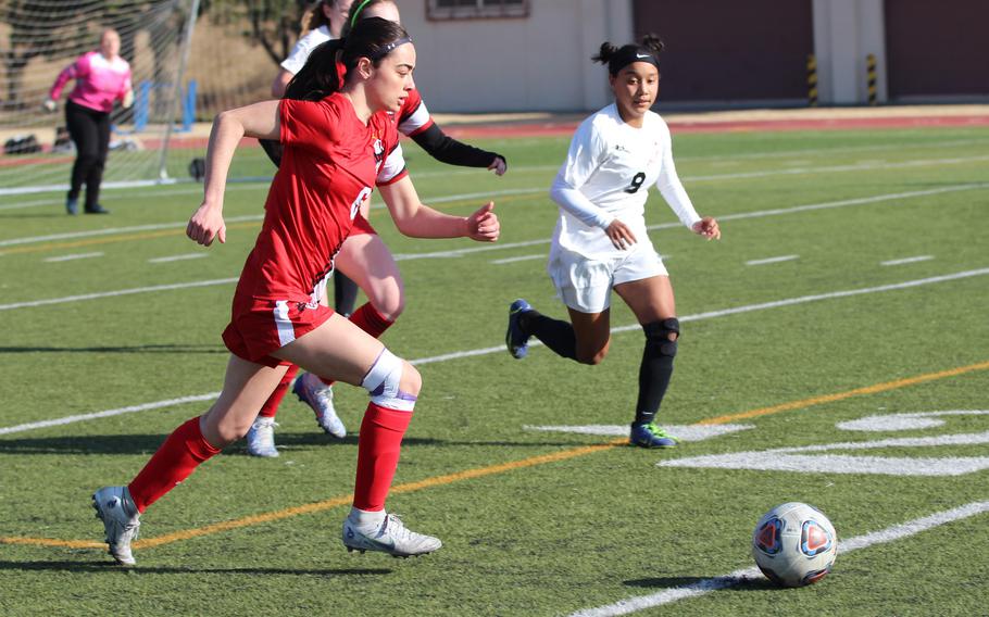 Nile C. Kinnick's Julia Angelinas drives the ball upfield against E.J. King's Miu Best during Friday's 3-2 Trojan War Cup win by the Red Devils.