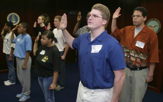 Army inductees, including Josh Anderson, center, take the oath of enlistment at the Federal Building in Richmond, Va., Thursday, April 3, 2003. Anderson said at the time that his resolve to join the Army during wartime was “stronger than ever.”