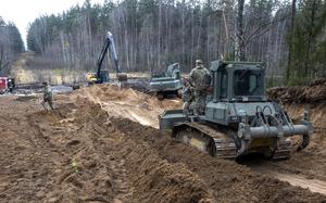 Crews with cranes and other vehicles work to find missing soldiers in swampy ground.