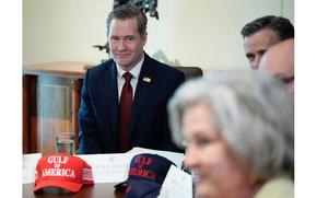 Four people at a table, Mike Waltz in being the only one in focus.