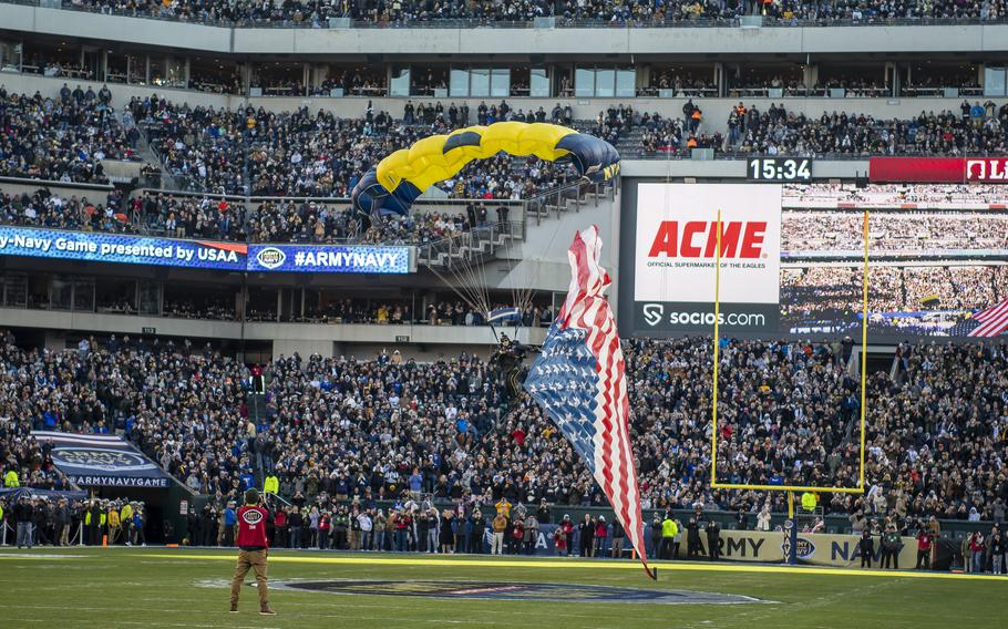 A Navy parachutists with an American flag trailing behind floats down from the sky prior to the start of the 123rd Army-Navy football game on Saturday, Dec. 10, 2022, during pre-game activities at Philadelphia’s Lincoln Financial Field.